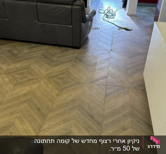 אדם מנקה רצפה עם צינור מים ודלי בחוץ